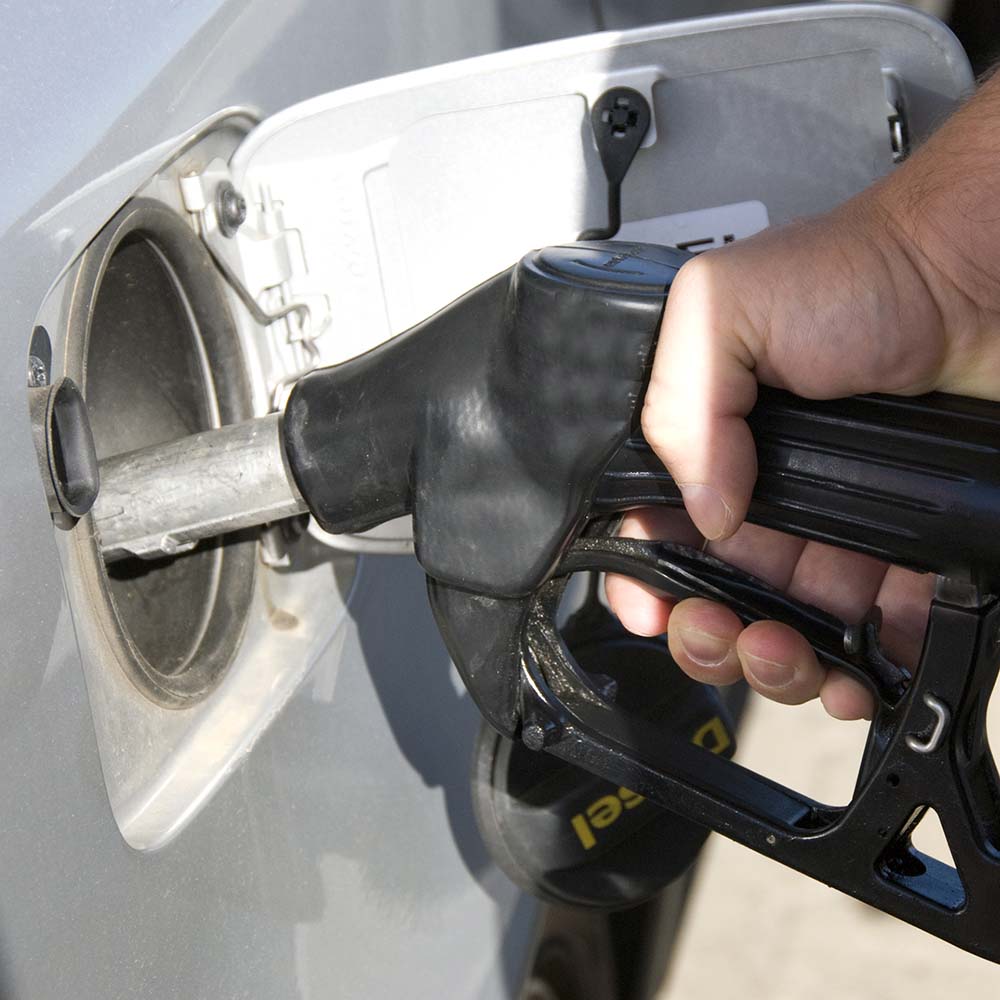 Close-up of a man s hand using a petrol pump to fill his car up with fuel