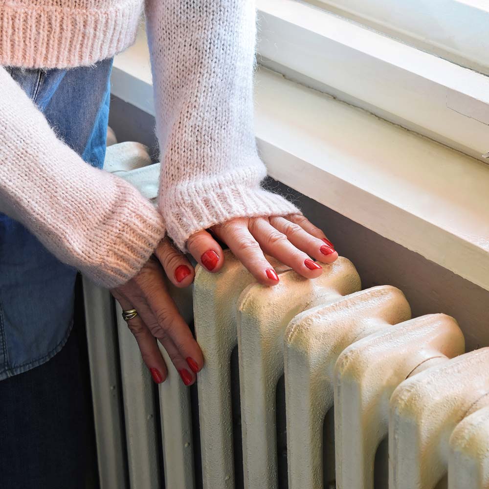 Woman feeling heat from a radiator